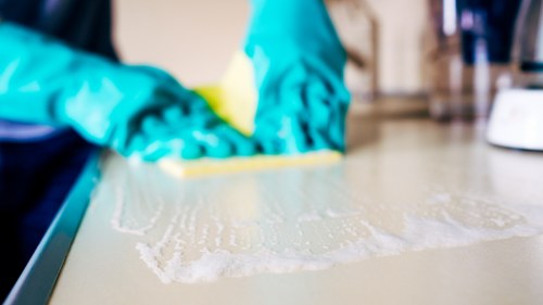 Local cleaner tidying a kitchen and living space in Swiss Cottage